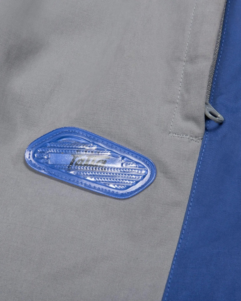 Lenticular Patta Air Max bubble badge and zippered pocket detail on grey and blue Nike track pants.